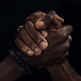 Image of two hands grasping one another as though helping each other